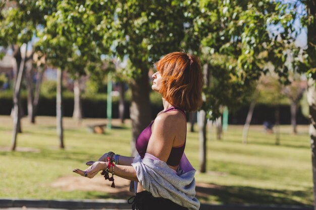 Mujer de jengibre meditando en un día soleado