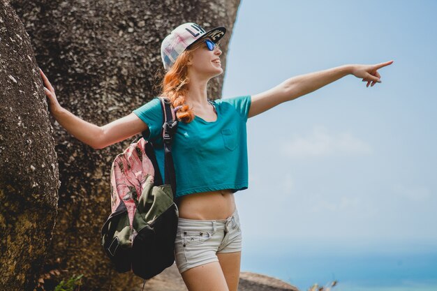 Mujer de jengibre viajando en las montañas, turista en vacaciones de verano