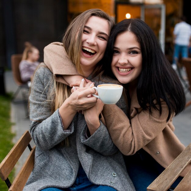 Mujer joven abrazada por su amiga