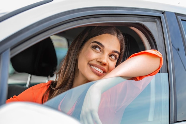 Foto gratuita mujer joven abrazando su coche nuevo mujer joven emocionada y su coche nuevo en el interior mujer joven y alegre disfrutando de coche nuevo