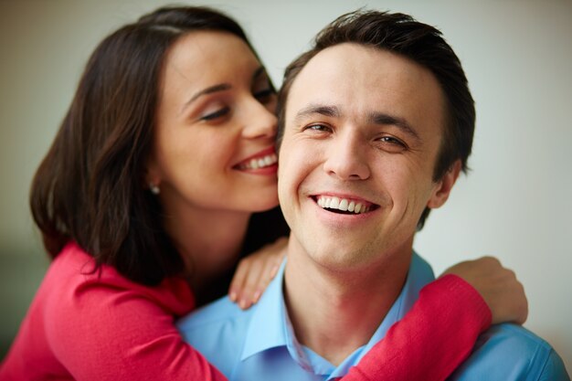 Foto gratuita mujer joven abrazándose al hombre desde atrás