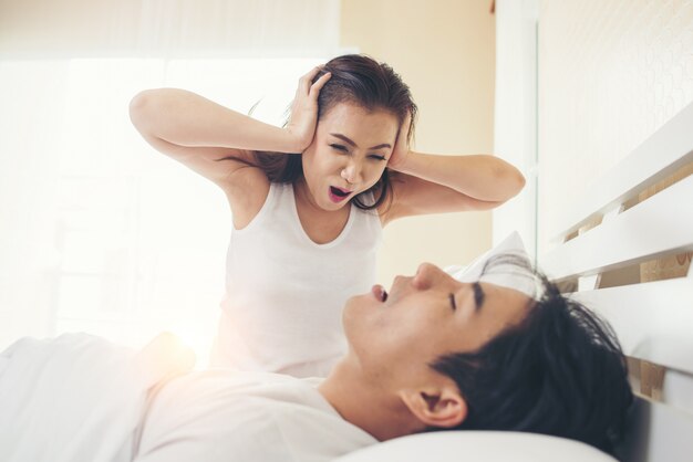 Mujer joven aburrida con su novio roncando