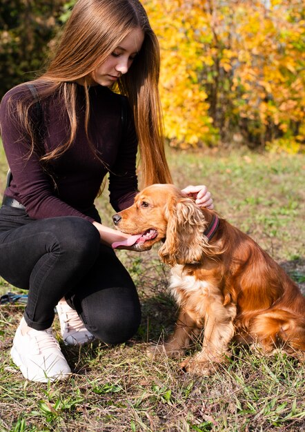 Mujer joven acariciando cocker spaniel