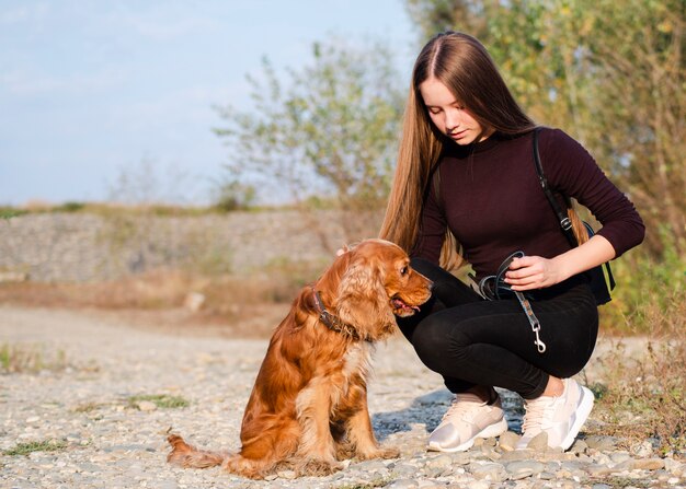 Mujer joven acariciando a un cocker spaniel