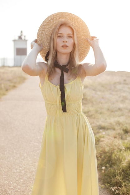 mujer joven y acogedora con sombrero en el campo