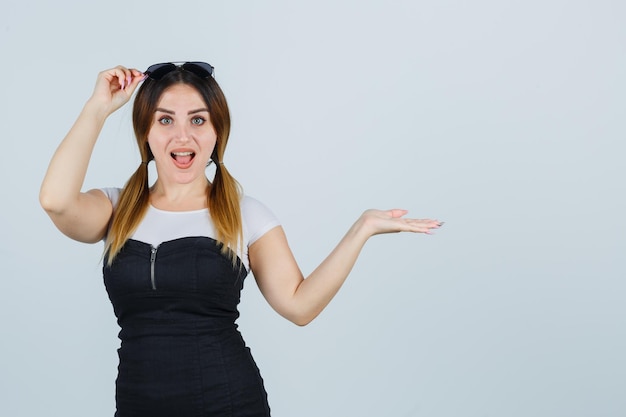 Mujer joven, actuación, algo, mientras, tenencia de la mano, anteojos