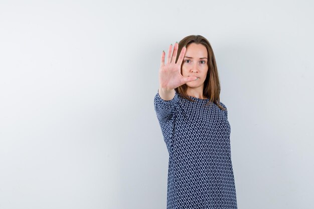 mujer joven, actuación, un, parada, señal de mano, blanco, plano de fondo