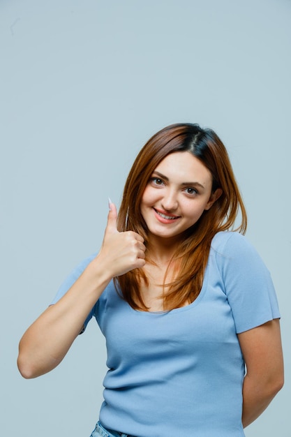 Mujer joven, actuación, pulgares arriba