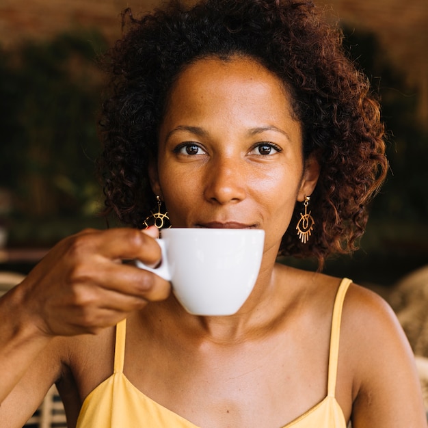 Una mujer joven afroamericana tomando café