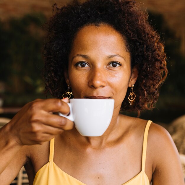 Una mujer joven afroamericana tomando café