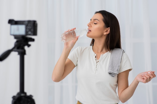 Foto gratuita mujer joven, agua potable, en cámara