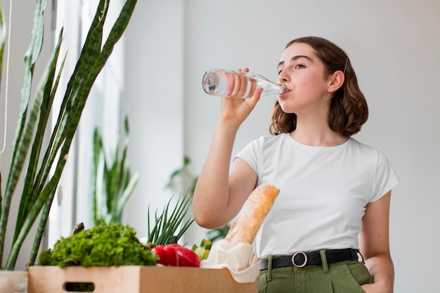 Foto gratuita mujer joven, agua potable, en casa