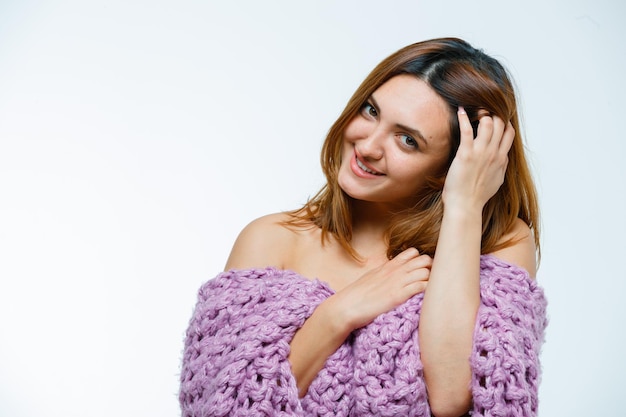 Foto gratuita mujer joven ajustando el cabello mientras posa