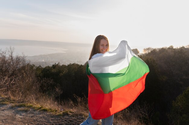 Mujer joven al aire libre sosteniendo la bandera búlgara