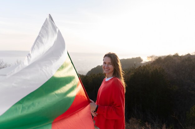 Mujer joven al aire libre sosteniendo la bandera búlgara