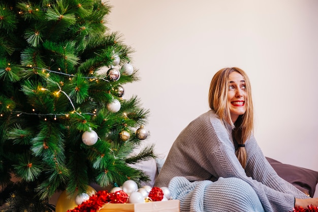 Foto gratuita mujer joven al lado de su árbol de navidad