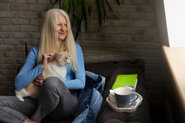 Mujer joven con albinismo y gato mascota