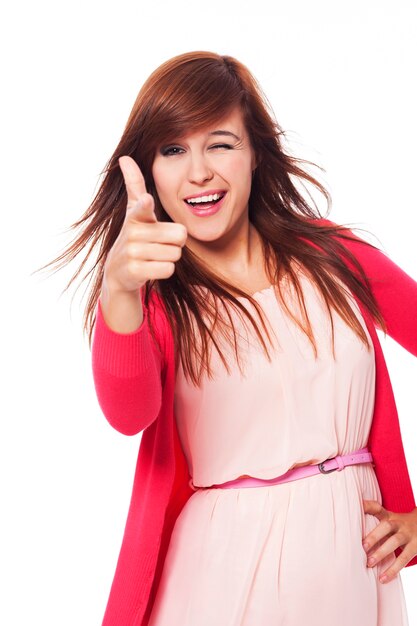 Mujer joven alegre apuntando a la cámara