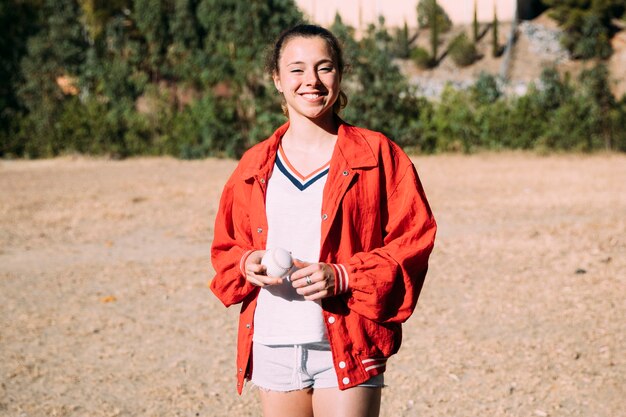 Mujer joven alegre en el campo de béisbol