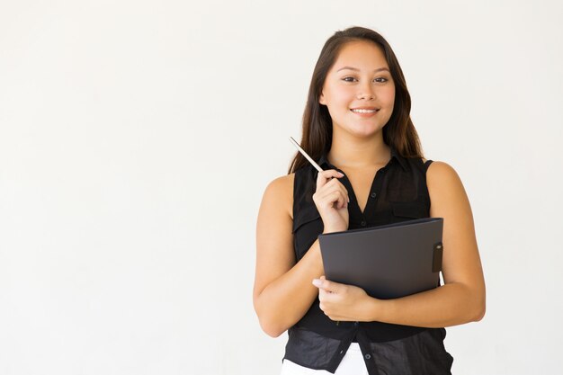 Mujer joven alegre con carpeta y pluma