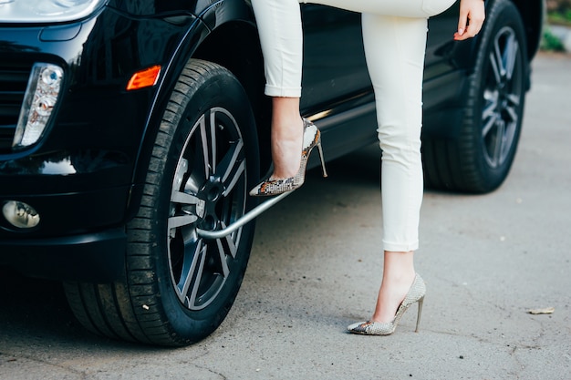 Foto gratuita mujer joven alegre con coche de lujo