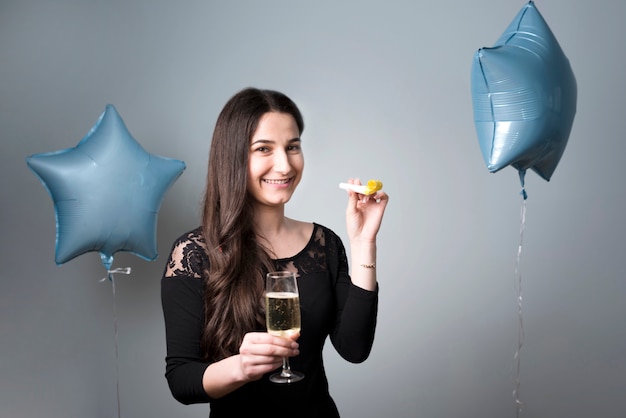 Mujer joven alegre con cuerno de cristal y fiesta