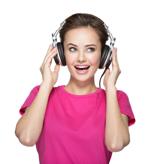 Mujer joven alegre escuchando música con auriculares