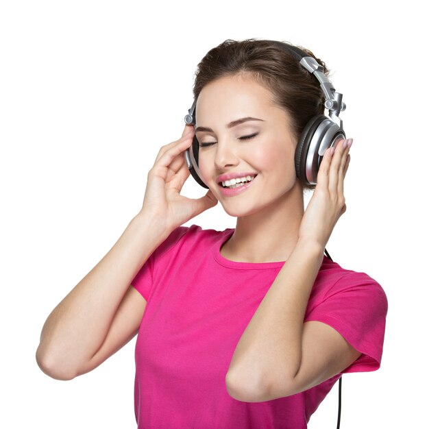 Mujer joven alegre escuchando música con auriculares
