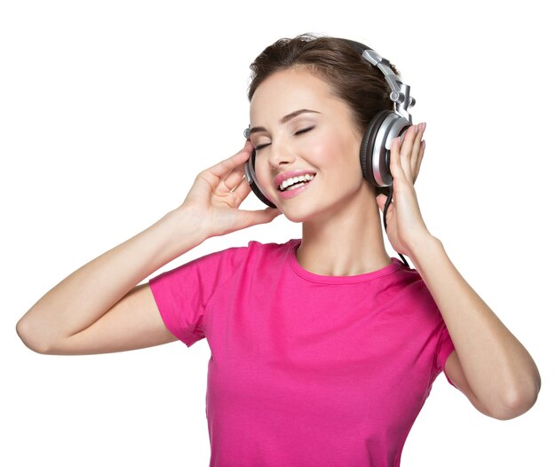 Mujer joven alegre escuchando música con auriculares