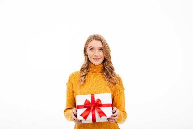 Mujer joven alegre linda que sostiene la caja de regalo de la sorpresa.