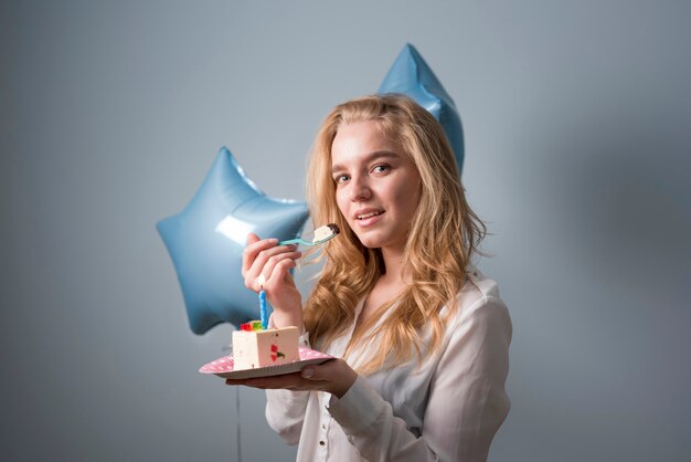 Mujer joven alegre con pastel de cumpleaños