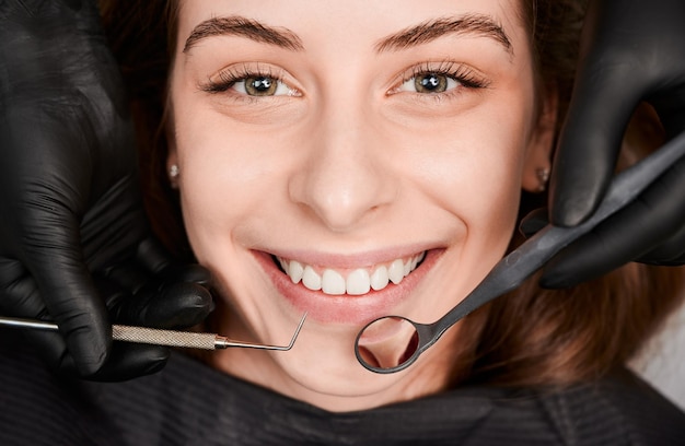 Foto gratuita mujer joven alegre que tiene un examen dental en la clínica