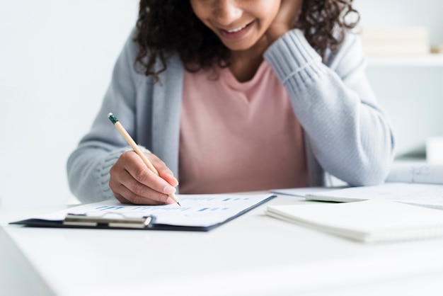 Mujer joven alegre que trabaja en lugar de trabajo