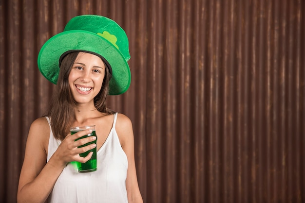 Mujer joven alegre con vaso de bebida