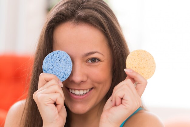 Mujer joven con almohadas cosméticas