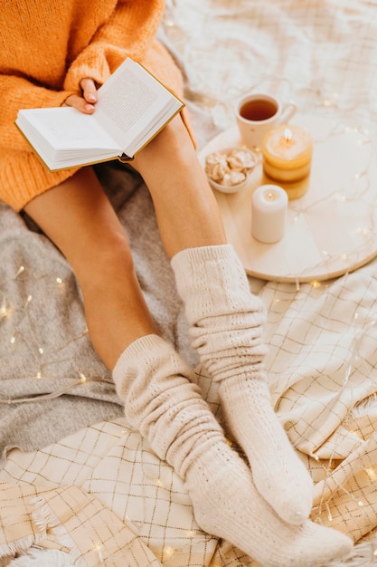 Mujer joven de alto ángulo disfrutando de las vacaciones de invierno con una taza de té