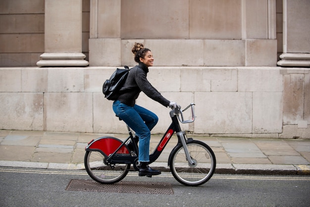 mujer joven, andar en bicicleta, en la ciudad