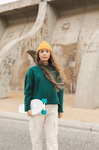 Mujer joven de ángulo bajo con patineta