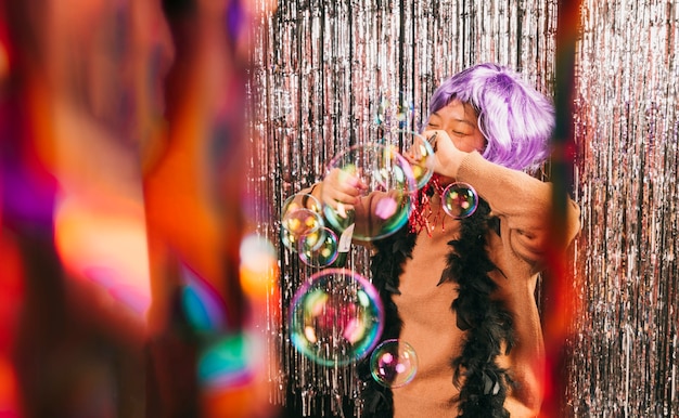 Mujer joven de ángulo bajo con peluca en fiesta de carnaval