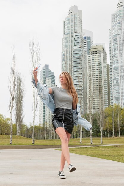 Mujer joven de ángulo bajo tomando selfie