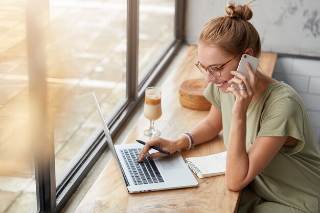 Mujer joven, con, anteojos, en, café