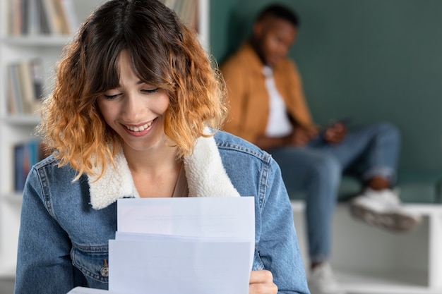 Foto gratuita mujer joven aprendiendo de notas durante la sesión de estudio