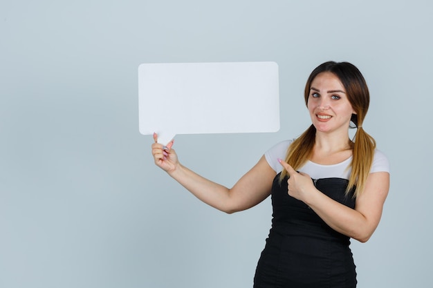 Foto gratuita mujer joven apuntando al bocadillo y mirando alegre