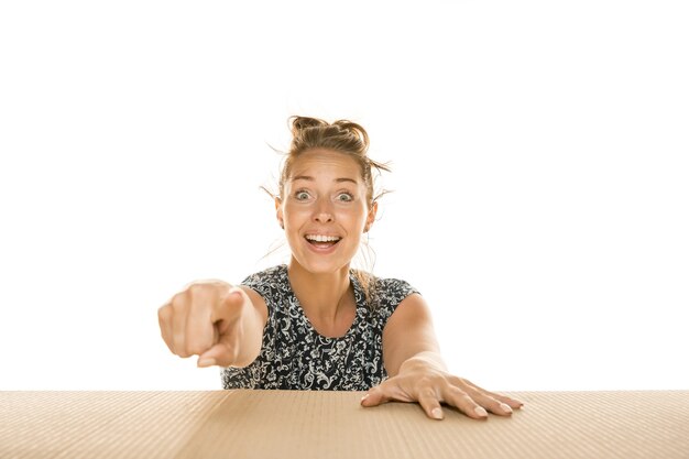 Mujer joven apuntando hacia el frente en una mesa woodent