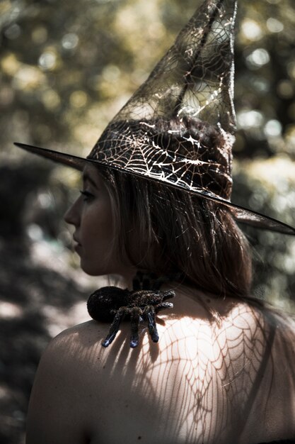 Mujer joven con araña en el bosque