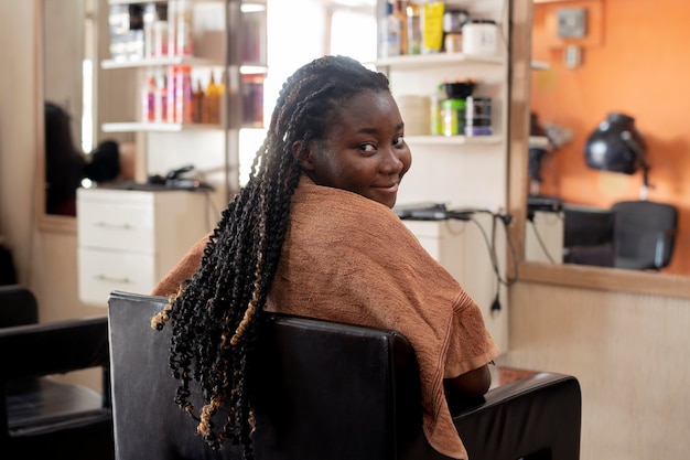 Mujer joven arreglando su cabello en el salón de belleza