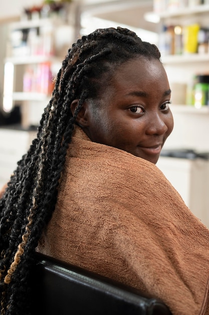 Foto gratuita mujer joven arreglando su cabello en el salón de belleza