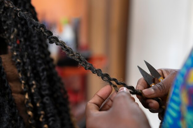 Mujer joven arreglando su cabello en el salón de belleza