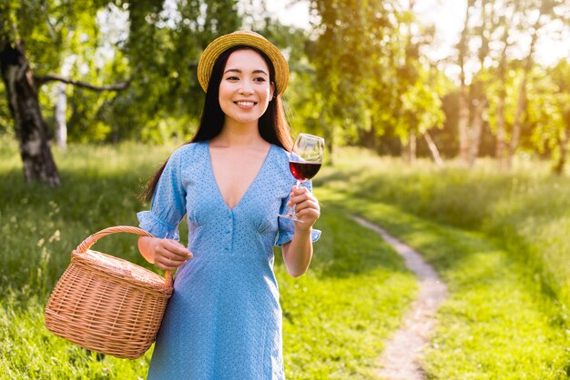 Mujer joven asiática con vidrio y cesta