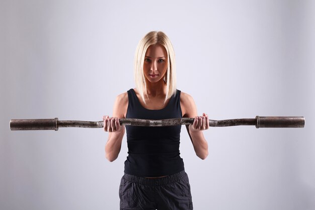 Mujer joven atleta con barra de ejercicio